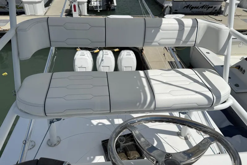 Huntress Yacht Photos Pics Helm seating on 2007 SeaHunter 40 boat, featuring white cushioned bench and steering wheel.