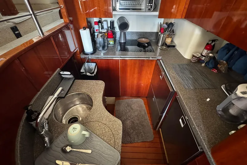 My Way Yacht Photos Pics Luxurious 2001 Fairline 55 yacht kitchen with modern appliances and elegant wood cabinetry.