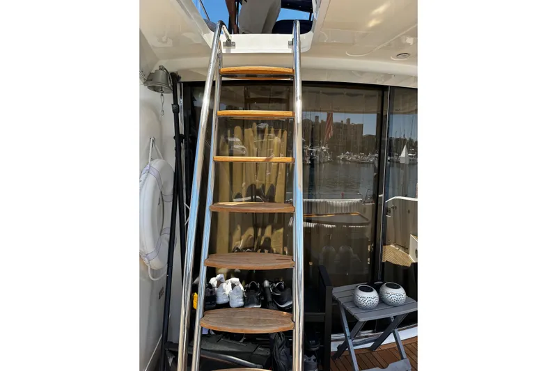 My Way Yacht Photos Pics Staircase on 2001 Fairline 55 yacht with marina view through glass doors.