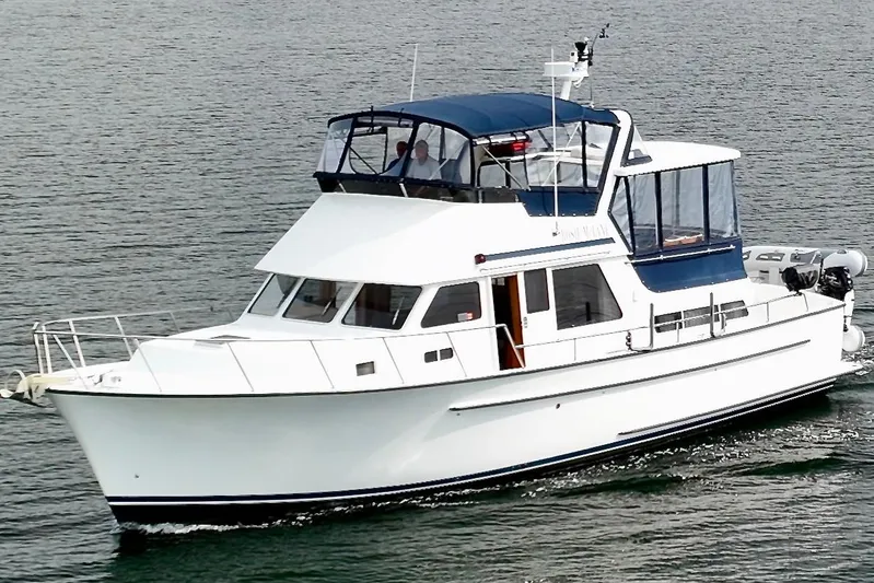 Rosie Mclane Yacht Photos Pics White 2006 Westcoast Sedan boat cruising on water with blue canopy.