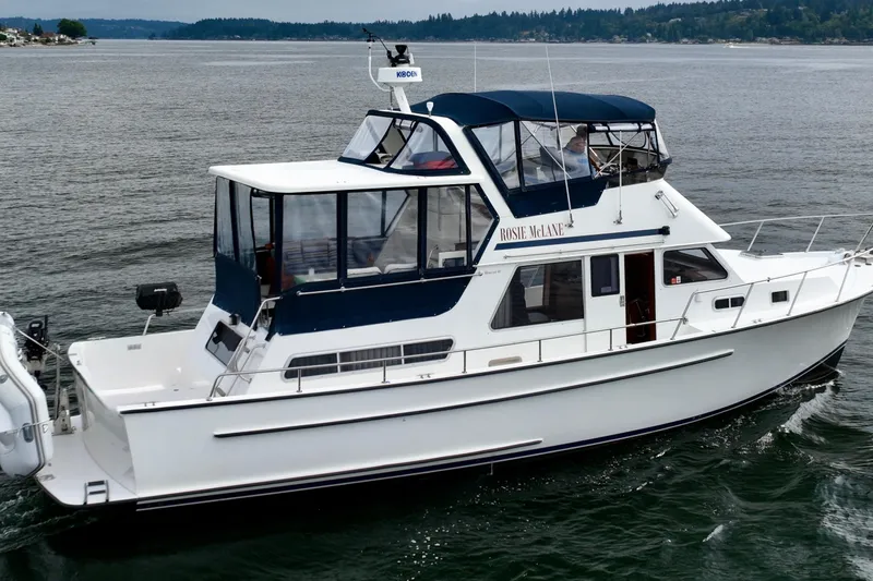 Rosie Mclane Yacht Photos Pics A white yacht named "Rosie McLane" cruising on a calm lake with distant shoreline.