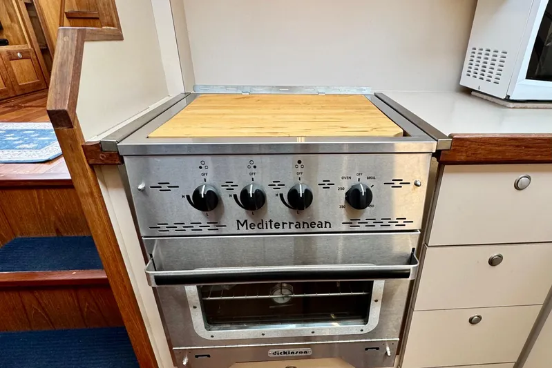 Rosie Mclane Yacht Photos Pics Stainless steel Mediterranean stove with wooden countertop in a cozy kitchen setting.