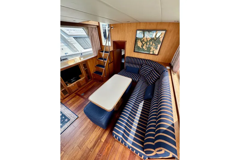Rosie Mclane Yacht Photos Pics Luxurious 2006 Westcoast Sedan interior with striped seating, wooden flooring, and nautical decor.
