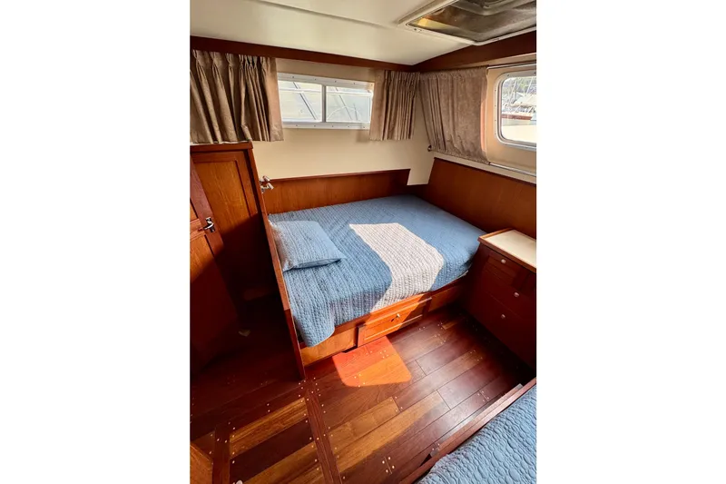 Rosie Mclane Yacht Photos Pics Cozy cabin interior of 2006 Westcoast Sedan with wooden furnishings and blue bedding.