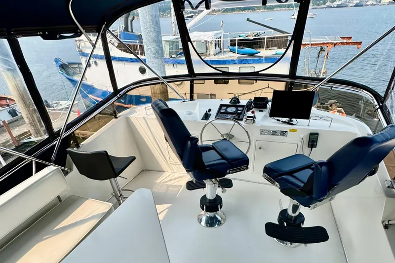 Rosie Mclane Yacht Photos Pics Interior view of a 2006 Westcoast Sedan boat cockpit with steering wheel and controls.