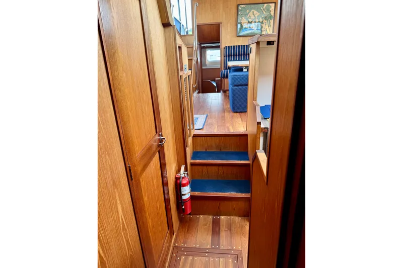 Rosie Mclane Yacht Photos Pics Interior of a 2006 Westcoast Sedan with wooden stairs and blue carpet.