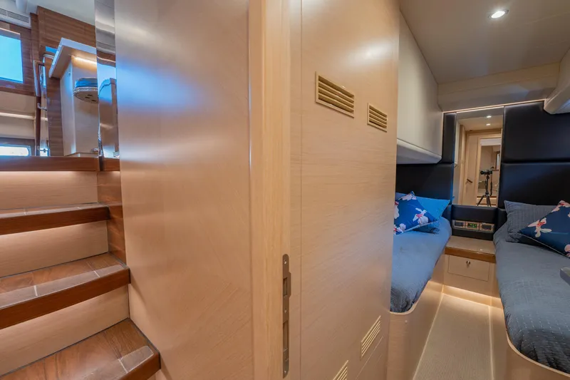Passion Yacht Photos Pics Luxurious interior of 2019 Horizon PC52 yacht with twin beds and wooden staircase.