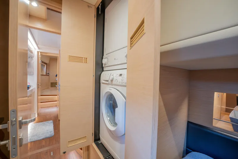 Passion Yacht Photos Pics Laundry area inside 2019 Horizon PC52 yacht, featuring a compact washing machine.