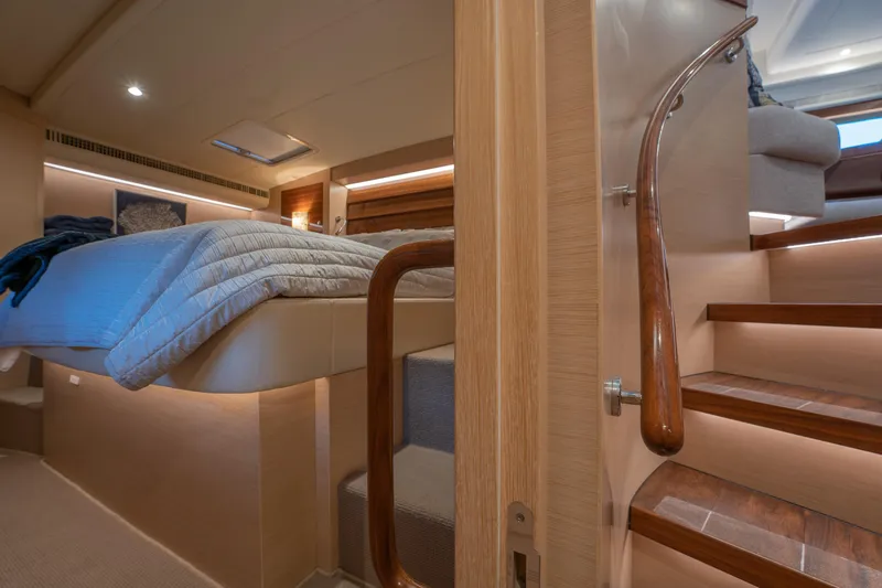 Passion Yacht Photos Pics Luxurious interior of 2019 Horizon PC52 yacht with cozy bedroom and elegant wooden staircase.