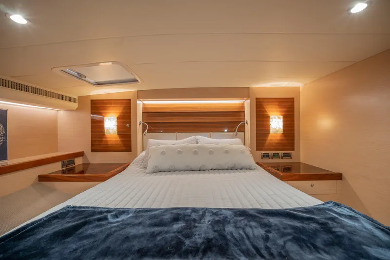 Passion Yacht Photos Pics Luxurious cabin interior of 2019 Horizon PC52 yacht with cozy bedding and ambient lighting.