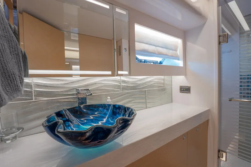 Passion Yacht Photos Pics Luxurious bathroom with a blue glass sink in a 2019 Horizon PC52 yacht.