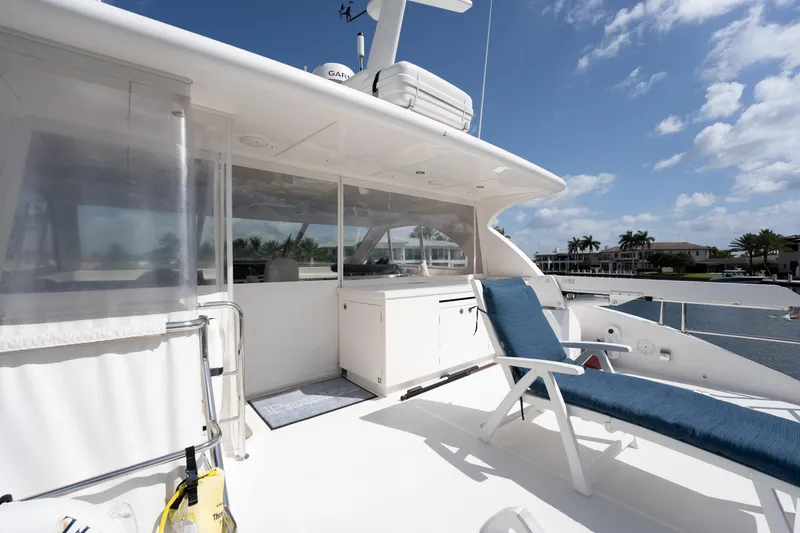 Passion Yacht Photos Pics Luxurious Horizon PC52 yacht deck with lounge chair, clear skies, and waterfront view.