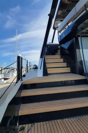  Yacht Photos Pics Luxury yacht Hussar WAVE 50, 2022 model, docked with wooden steps and sleek design.