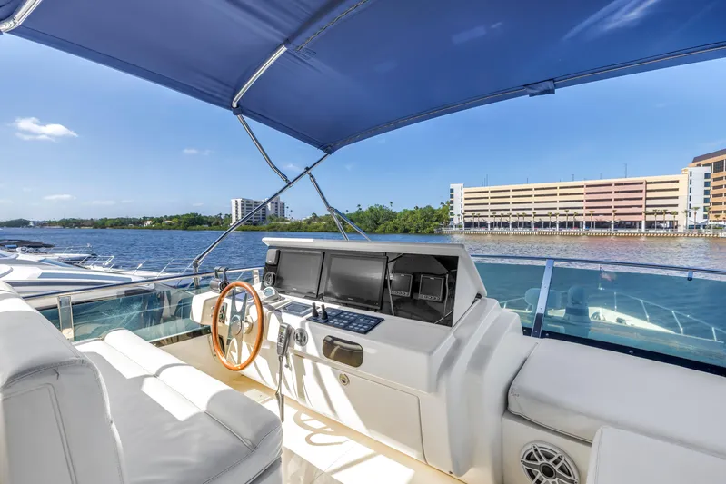 Solaris Yacht Photos Pics 2009 Uniesse 65 MY yacht helm with blue canopy, overlooking waterfront buildings.