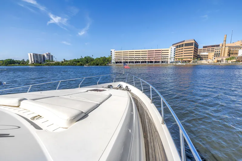 Solaris Yacht Photos Pics Bow view of 2009 Uniesse 65 MY yacht cruising near urban waterfront buildings.