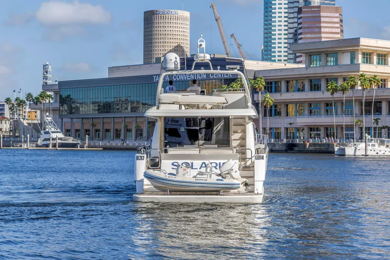 Solaris Yacht Photos Pics 2009 Uniesse 65 MY yacht in urban harbor, cityscape background.