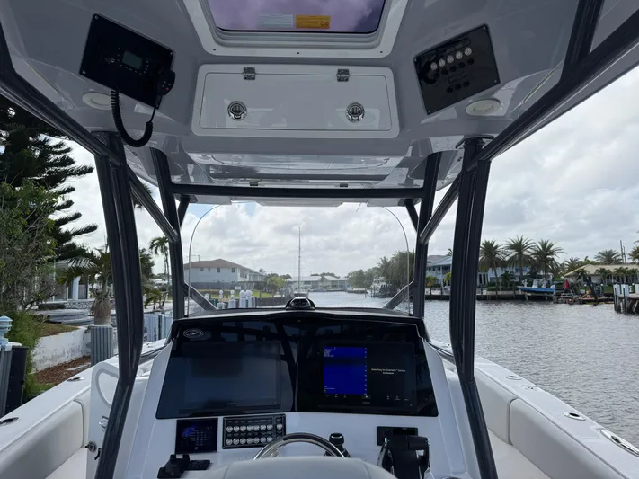 Keri B III Yacht Photos Pics 2023 Sea Fox 328 Commander boat cockpit with advanced navigation systems, docked by a scenic canal.