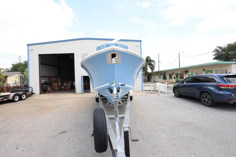  Yacht Photos Pics 2022 Cobia 301 Center Console boat on trailer outside a warehouse.