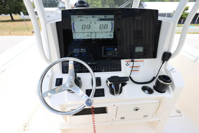  Yacht Photos Pics 2022 Cobia 301 Center Console boat dashboard with steering wheel and electronic controls.