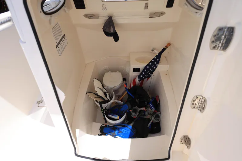  Yacht Photos Pics 2022 Cobia 301 Center Console storage area with gear and American flag.