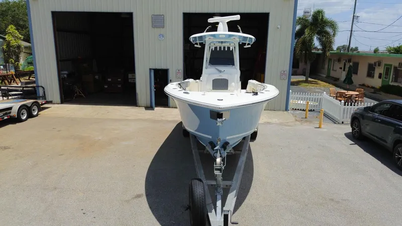  Yacht Photos Pics 2022 Cobia 301 Center Console boat on trailer outside a garage.
