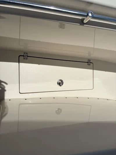  Yacht Photos Pics 2022 Cobia 301 Center Console storage compartment with latch, featuring sleek design and stainless steel railing.