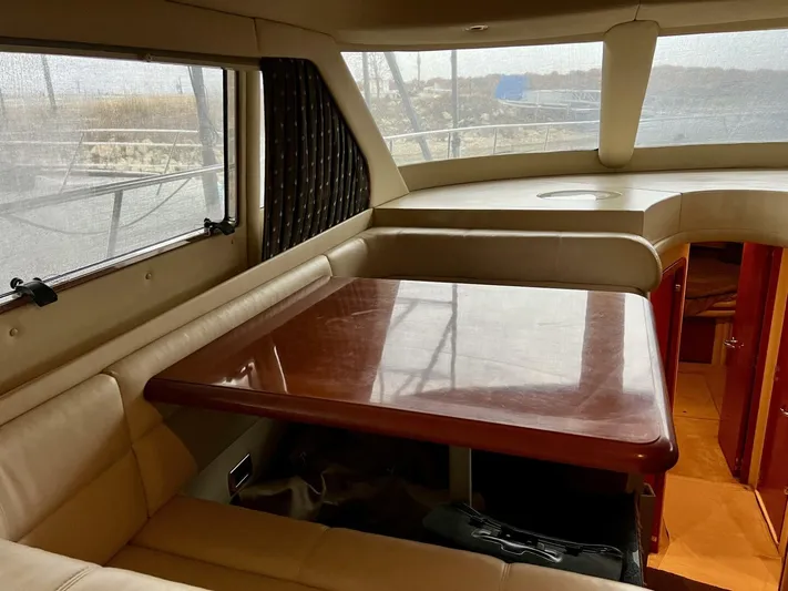 Moderation Yacht Photos Pics Interior of 2001 Sea Ray 56 Sedan Bridge with dining table and leather seating.