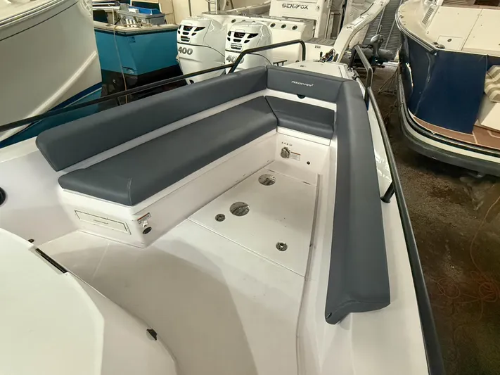 Underestimated Yacht Photos Pics 2021 Axopar 28 CABIN boat interior with cushioned seating in a showroom.