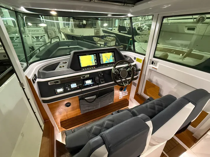 Underestimated Yacht Photos Pics 2021 Axopar 28 CABIN interior with modern dashboard and navigation equipment.
