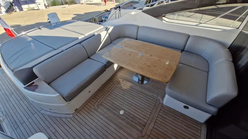 Yacht Photos Pics Luxurious seating area on 2012 Princess V57 yacht with wooden table and cushioned benches.