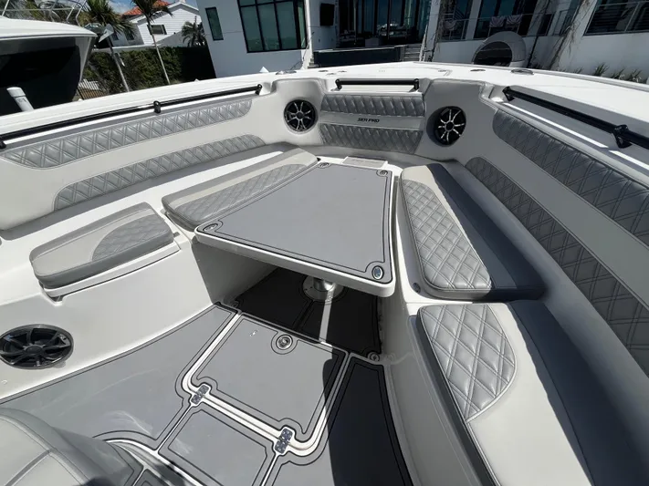  Yacht Photos Pics 2022 Seapro 320 DLX boat interior with gray seating and table, featuring modern design elements.