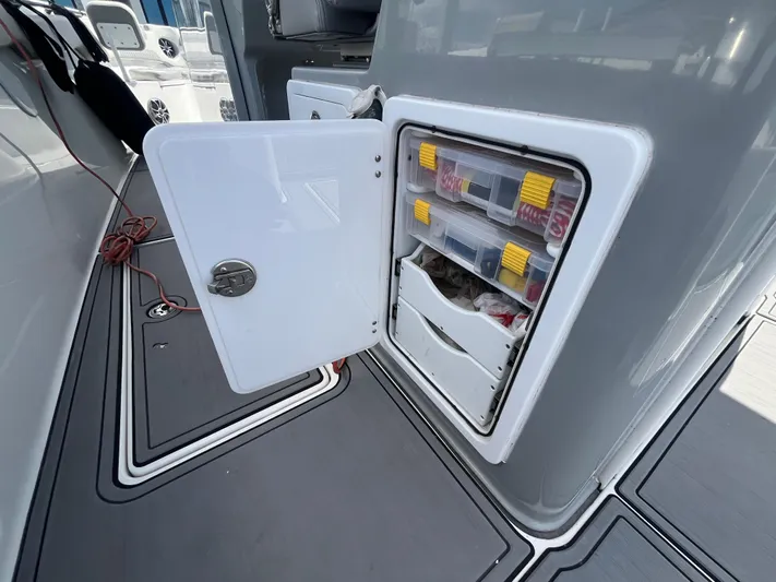  Yacht Photos Pics 2022 Seapro 320 DLX boat storage compartment with organized tackle boxes and accessories.