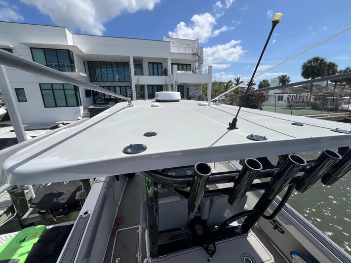  Yacht Photos Pics 2022 Seapro 320 DLX boat docked near modern waterfront home under blue sky.