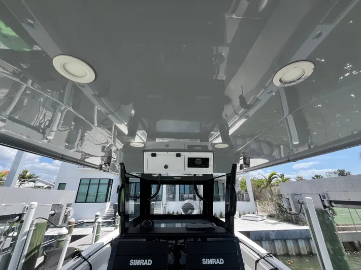  Yacht Photos Pics 2022 Seapro 320 DLX boat interior with Simrad equipment, docked near modern waterfront homes.