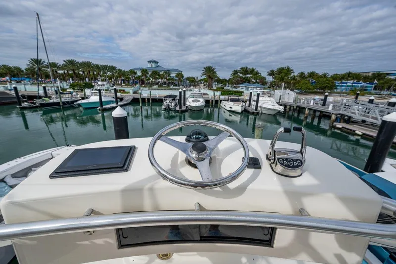 Sore Subject Yacht Photos Pics Helm of 2007 Albemarle 36 Express overlooking marina with boats and palm trees.