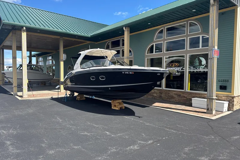  Yacht Photos Pics 2017 Chaparral 337 SSX boat displayed outside a showroom under a green roof.