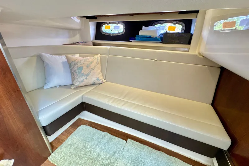  Yacht Photos Pics 2017 Chaparral 337 SSX cabin interior with cozy seating and nautical-themed pillows.
