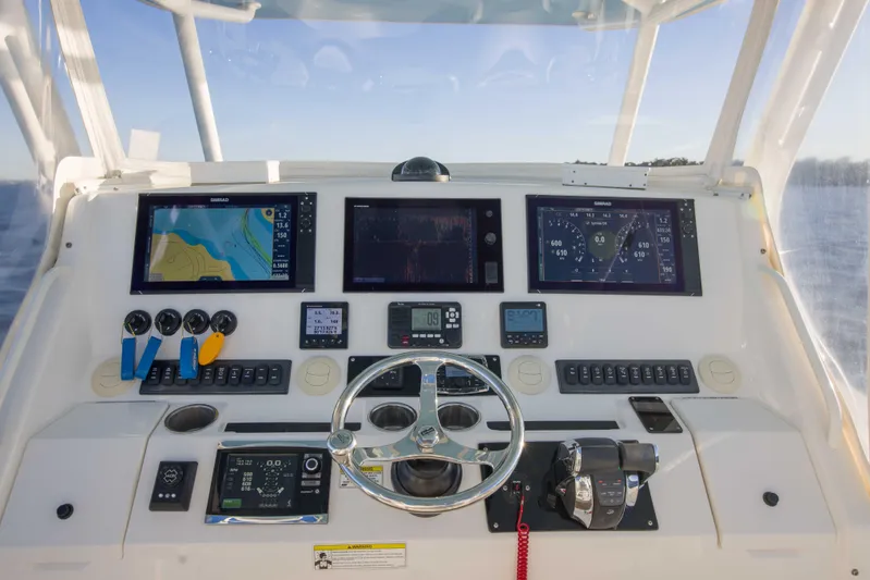 Wound Up II Yacht Photos Pics Control panel of a 2016 Regulator 41 boat with navigation screens and steering wheel.