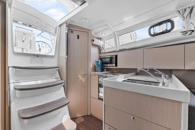 Eugenia Yacht Photos Pics Interior of 2021 Beneteau Oceanis 35.1 yacht, featuring modern kitchen and staircase.