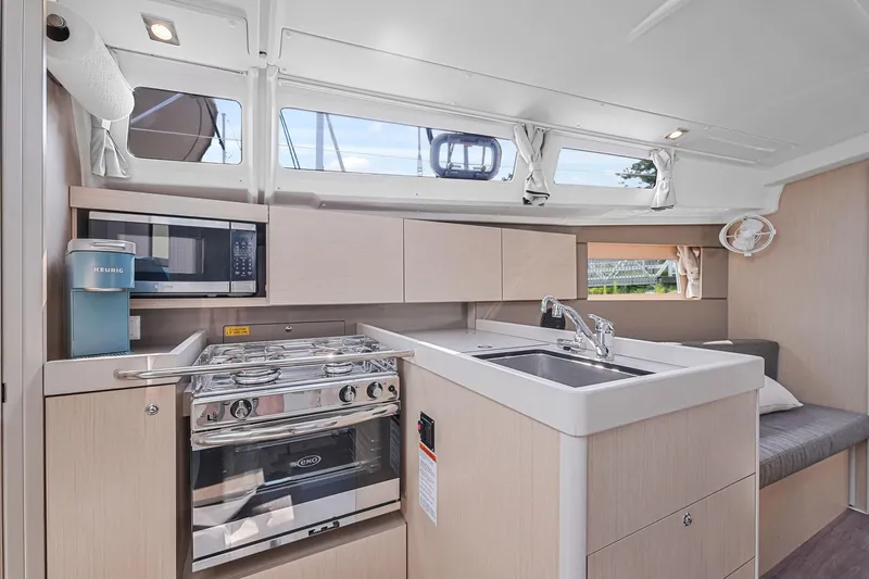 Eugenia Yacht Photos Pics Modern kitchen interior of 2021 Beneteau Oceanis 35.1 yacht with stove, sink, and microwave.