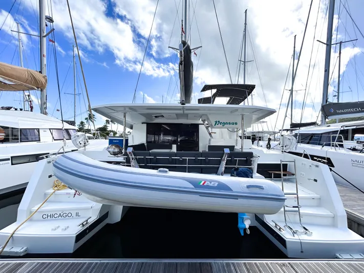 Pegasus Yacht Photos Pics 2022 Fountaine Pajot Astrea 42 catamaran docked with inflatable boat, clear sky background.
