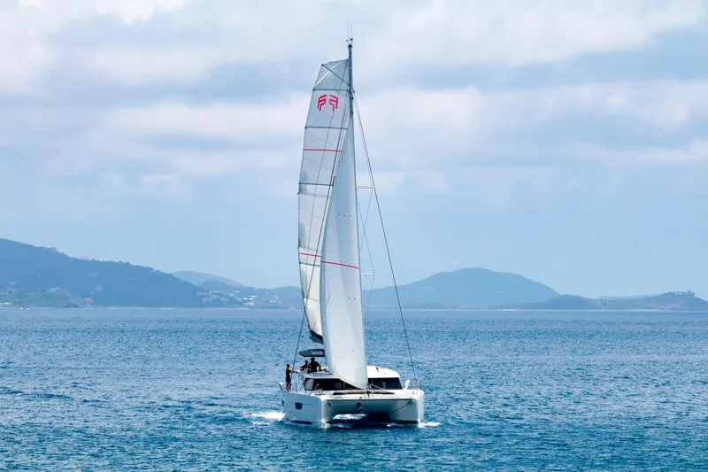 Pegasus Yacht Photos Pics 2022 Fountaine Pajot Astrea 42 catamaran sailing on open sea with distant hills.