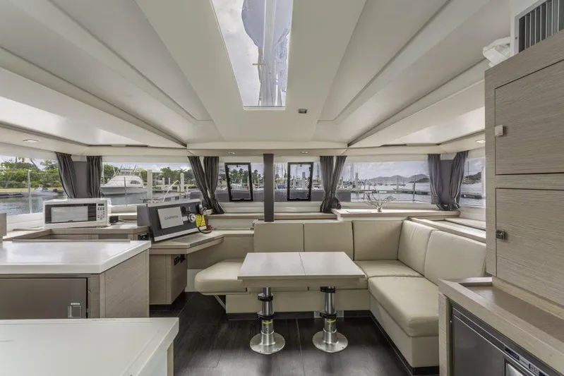 Pegasus Yacht Photos Pics Luxurious interior of 2022 Fountaine Pajot Astrea 42 catamaran with modern furnishings and ample seating.