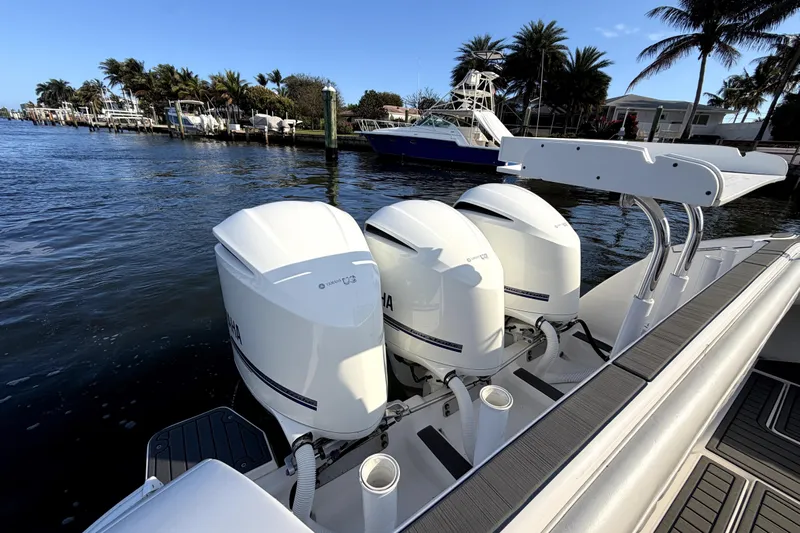  Yacht Photos Pics 2014 Intrepid 400 Cuddy with triple Yamaha outboard engines docked by the water.