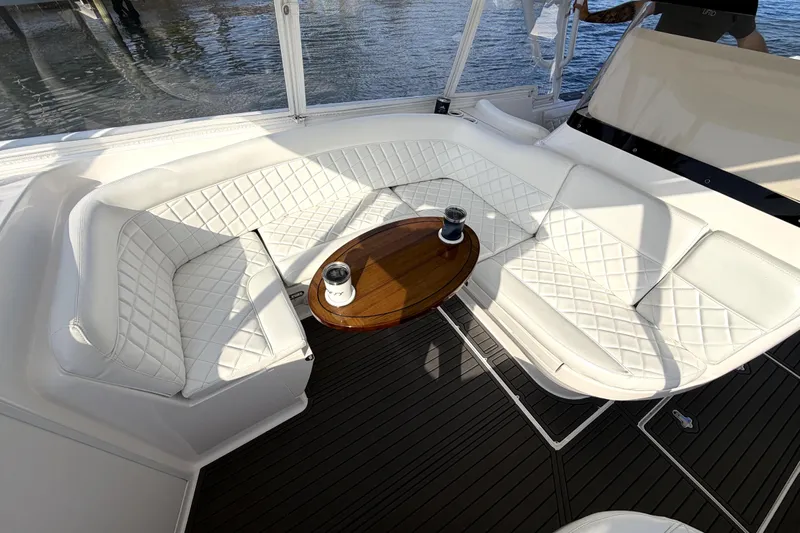  Yacht Photos Pics Luxurious seating area on 2014 Intrepid 400 Cuddy boat with white cushions and wooden table.