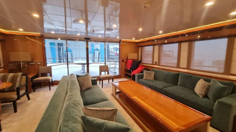  Yacht Photos Pics Luxurious yacht interior with plush seating, wooden table, and large windows, Custom 46 M, 2018 model.