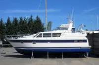 2007 Trader 42 yacht on dry dock, white and blue hull, clear sky background.