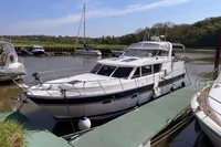 2007 Trader 42 yacht docked at a marina, surrounded by calm waters and greenery.