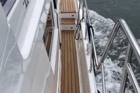Side deck of a 2007 Trader 42 yacht with teak flooring and stainless steel railings.