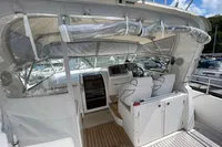 2007 Trader 42 yacht cockpit with helm, seating, and clear canopy under blue sky.
